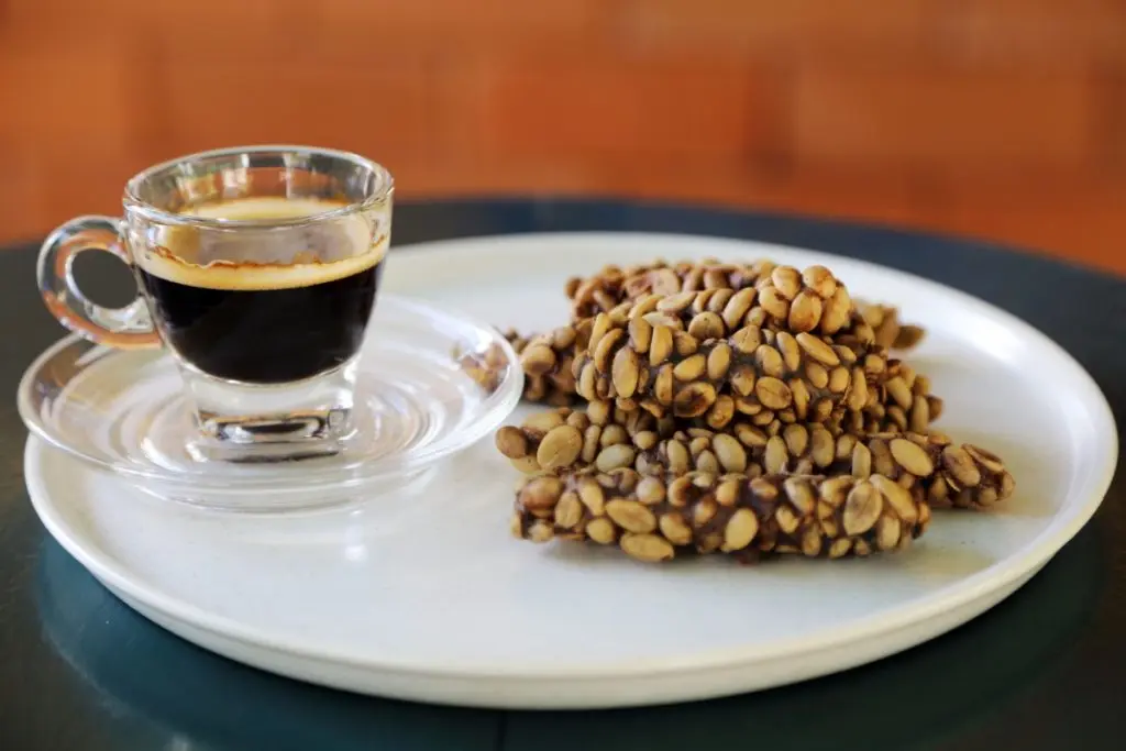 Kopi Luwak Coffee in the cup on the plate near the sweets