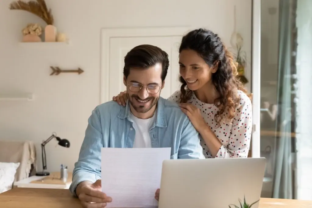 happy couple looking to the paper with a credit report