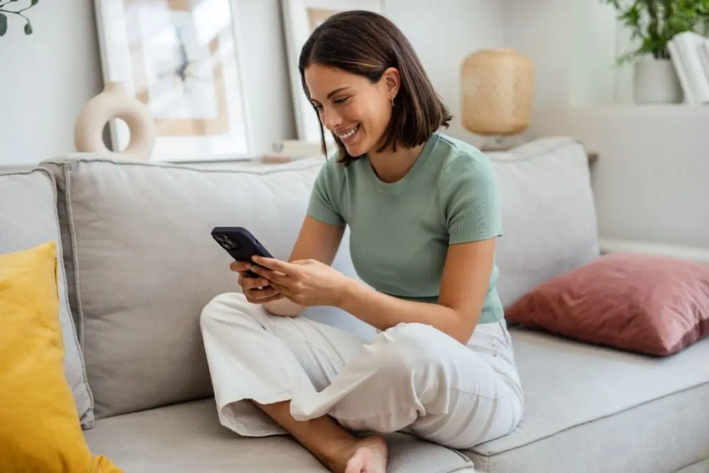 smiling woman looking at the smartphone