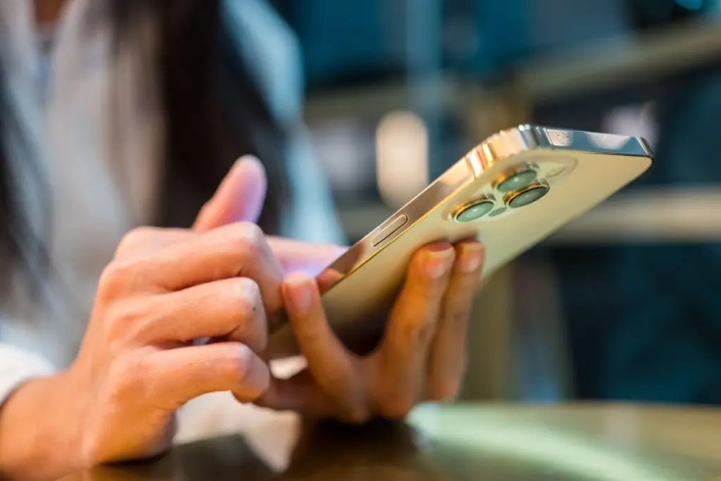 woman holding gold iphone pro