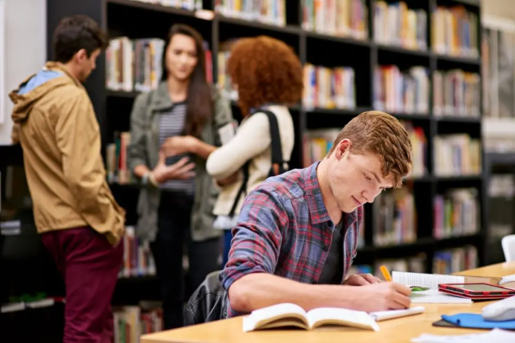 student doing homework in the college library