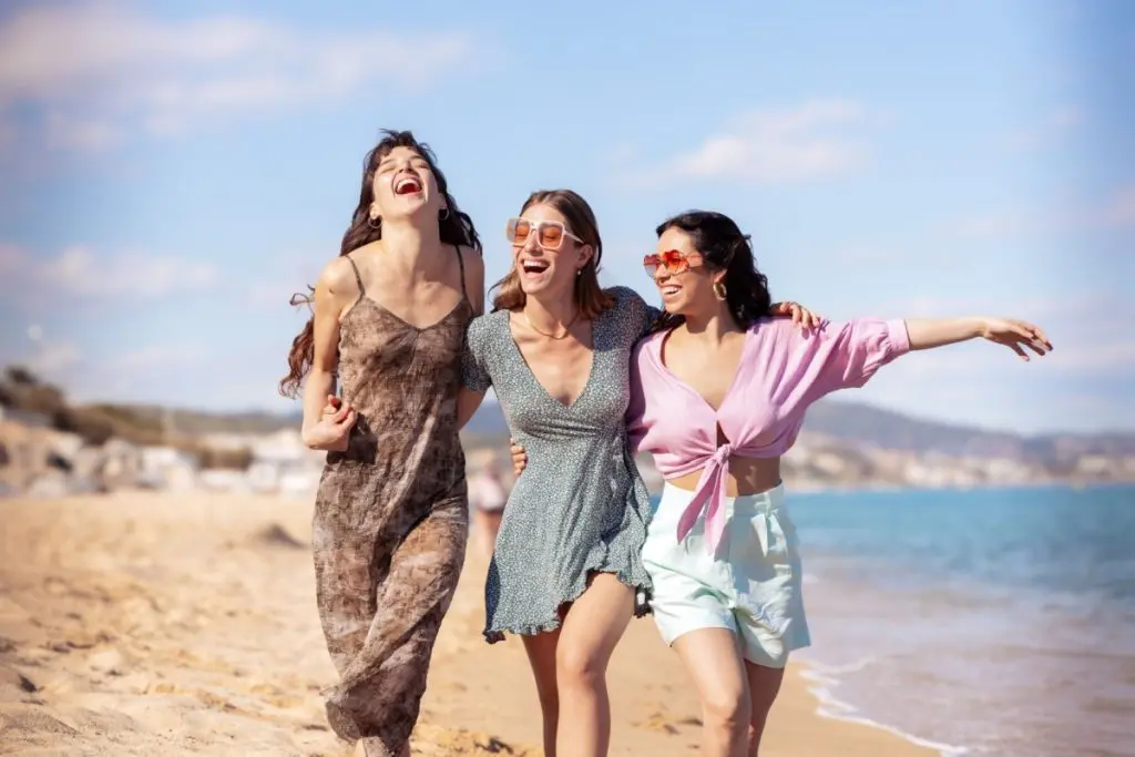 Three woman walking and laughing on the beach