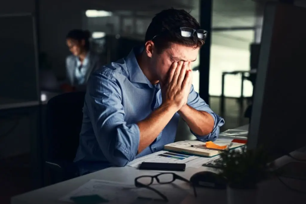 tired office man with hands on his face