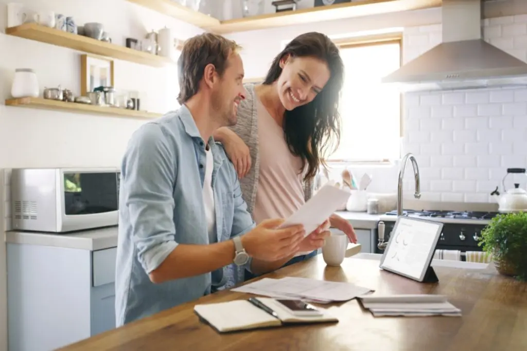 Happy couple watching at the paper with a good credit score