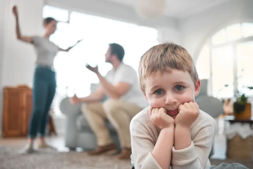 sad boy and parents who are arguing on the behind