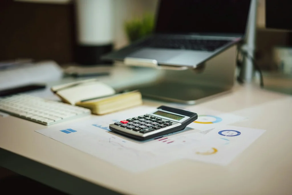 calulator with paper and bills on the table