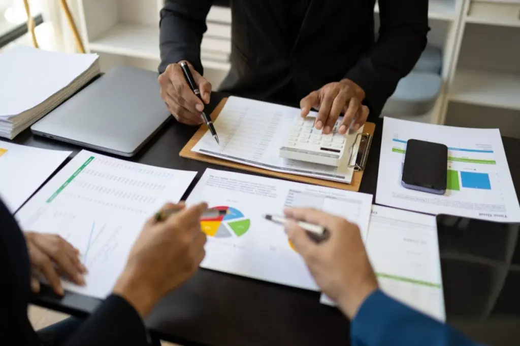 humans' hands with pens creating a budget 