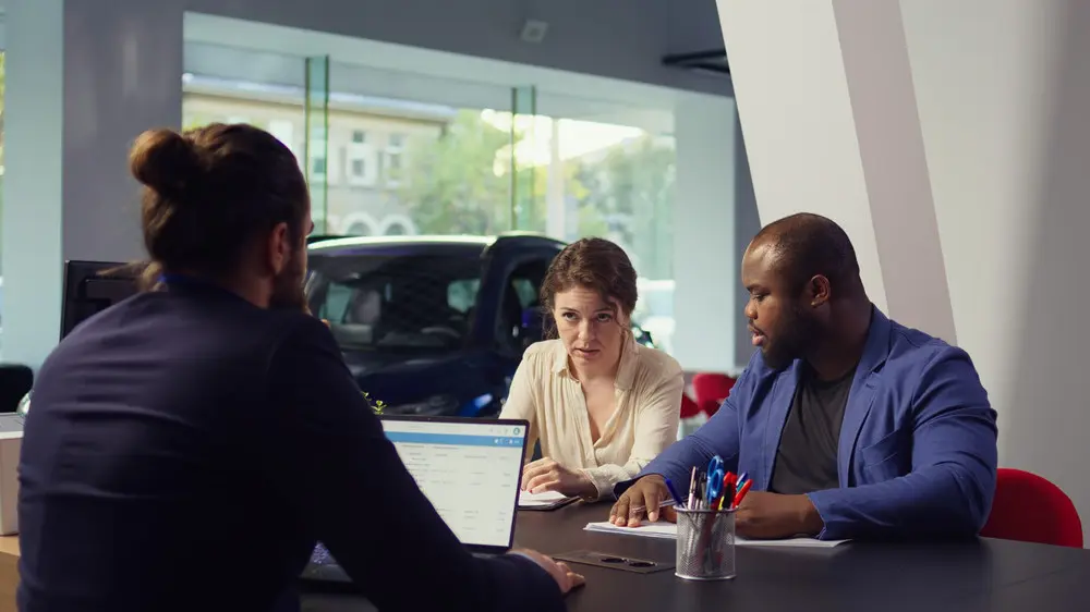 Couple at car dealership undergoing a credit check.