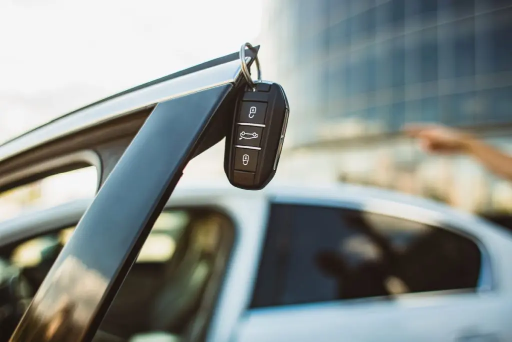 Car keys hanging from the door handle of a parked car