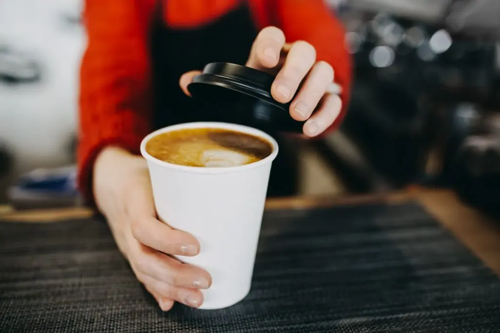 Barista holding coffee cup