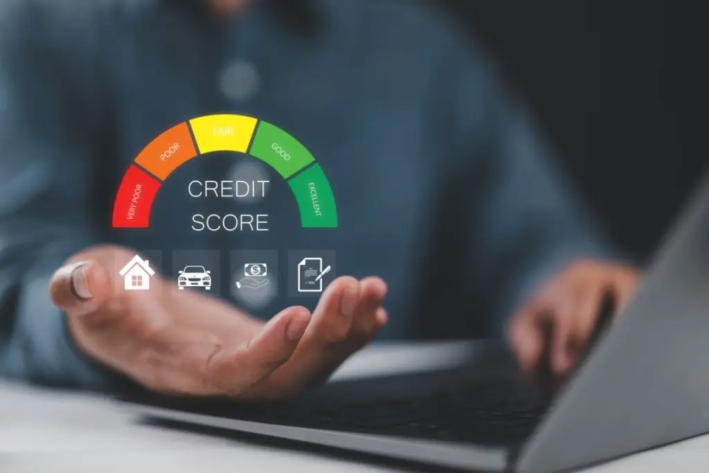 Credit score graphic above man's hand as he uses laptop.