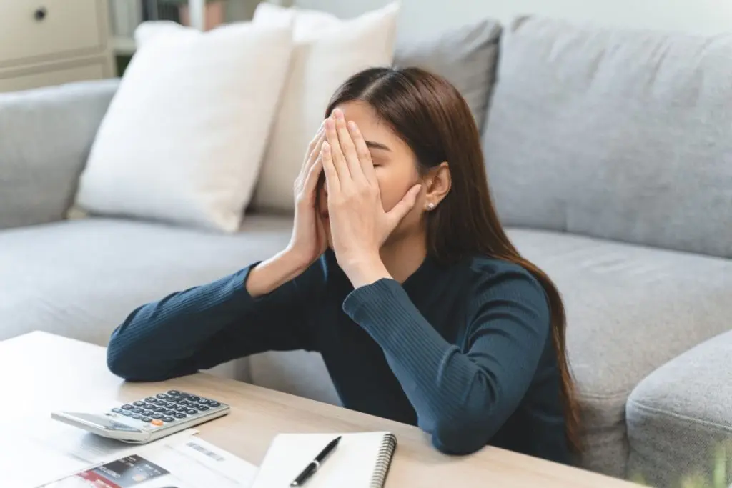 woman stressed out holding hands on her face at home