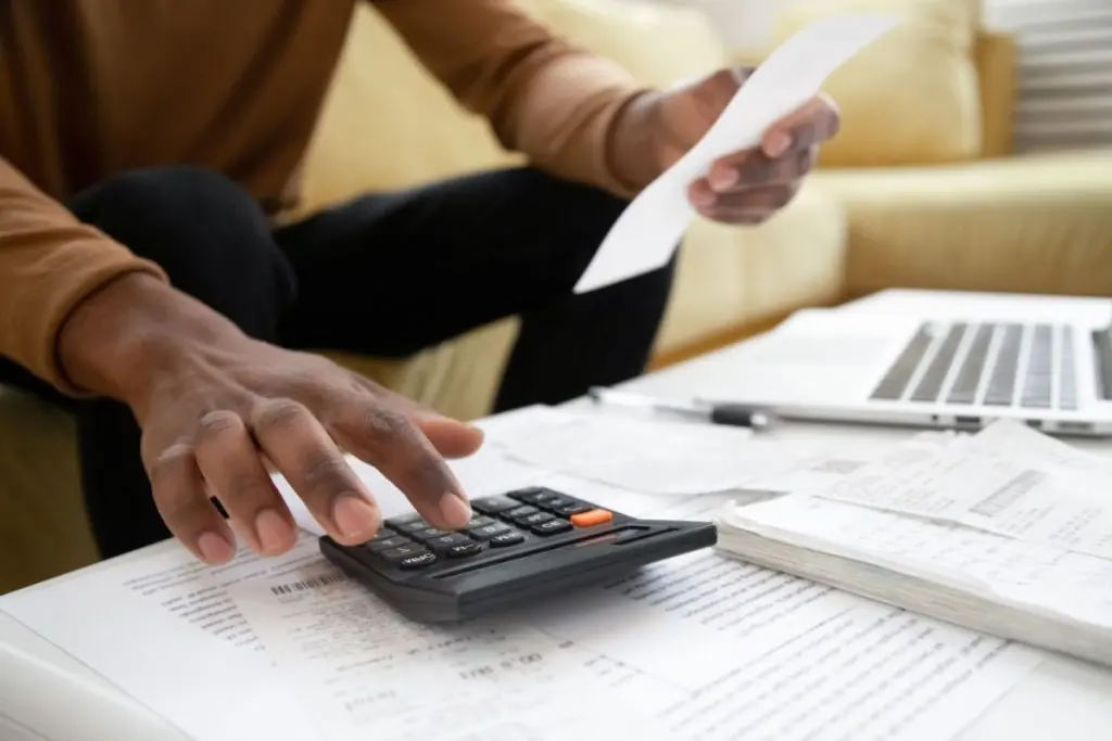 man counting debt on calculator