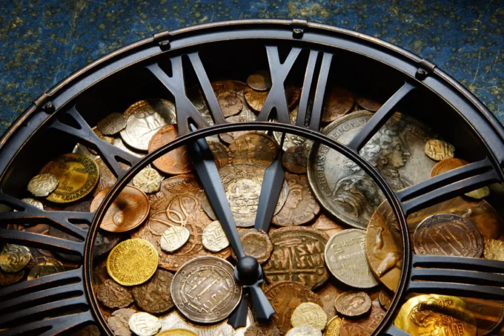 Clock with money in it representing the history of money