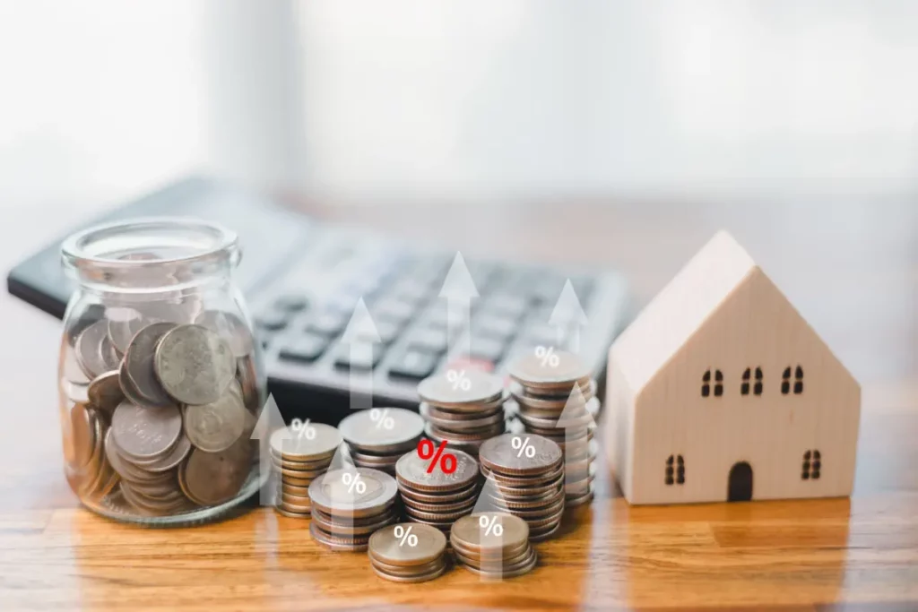 image of tiny toy house, a calculator, and coins