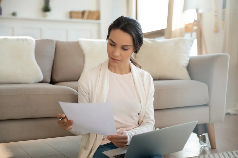 Woman reviewing financial information on a laptop after moving into a new apartment