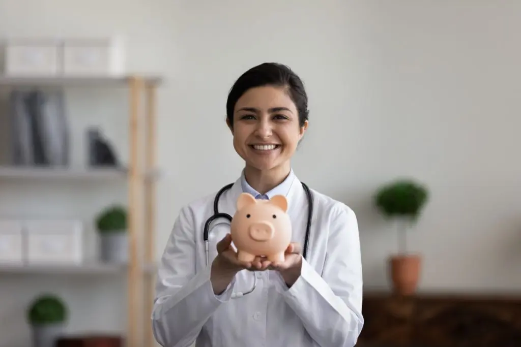 Nurse holding up a piggy bank