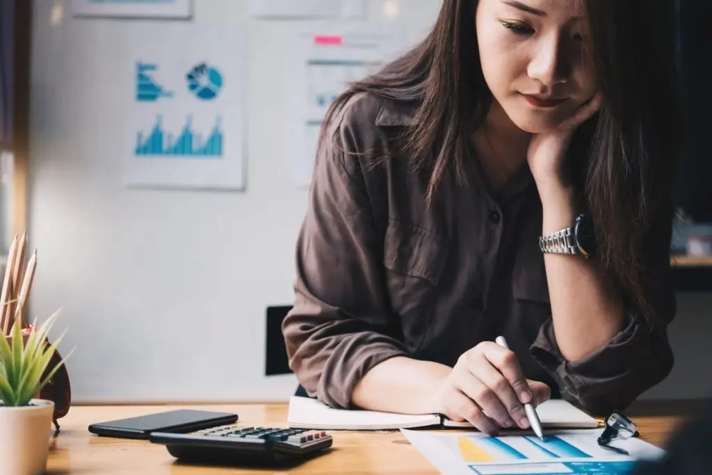 woman holding a pen and calculating finances