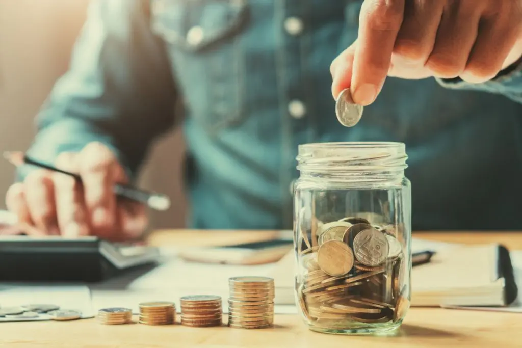 Person putting money in piggybank