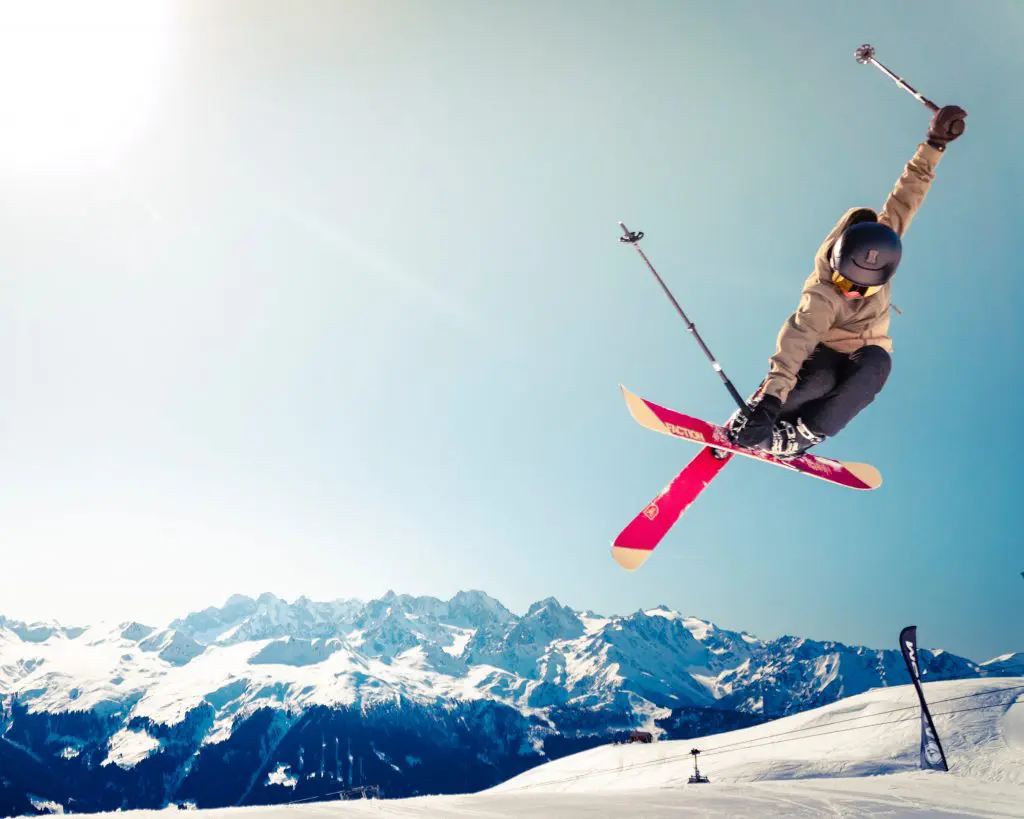 professional skier performing a jump on ski slopes