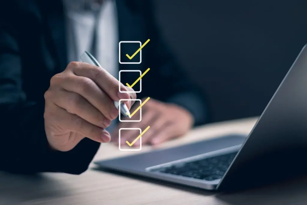 A man's hand placing checkmarks for taking a survey.